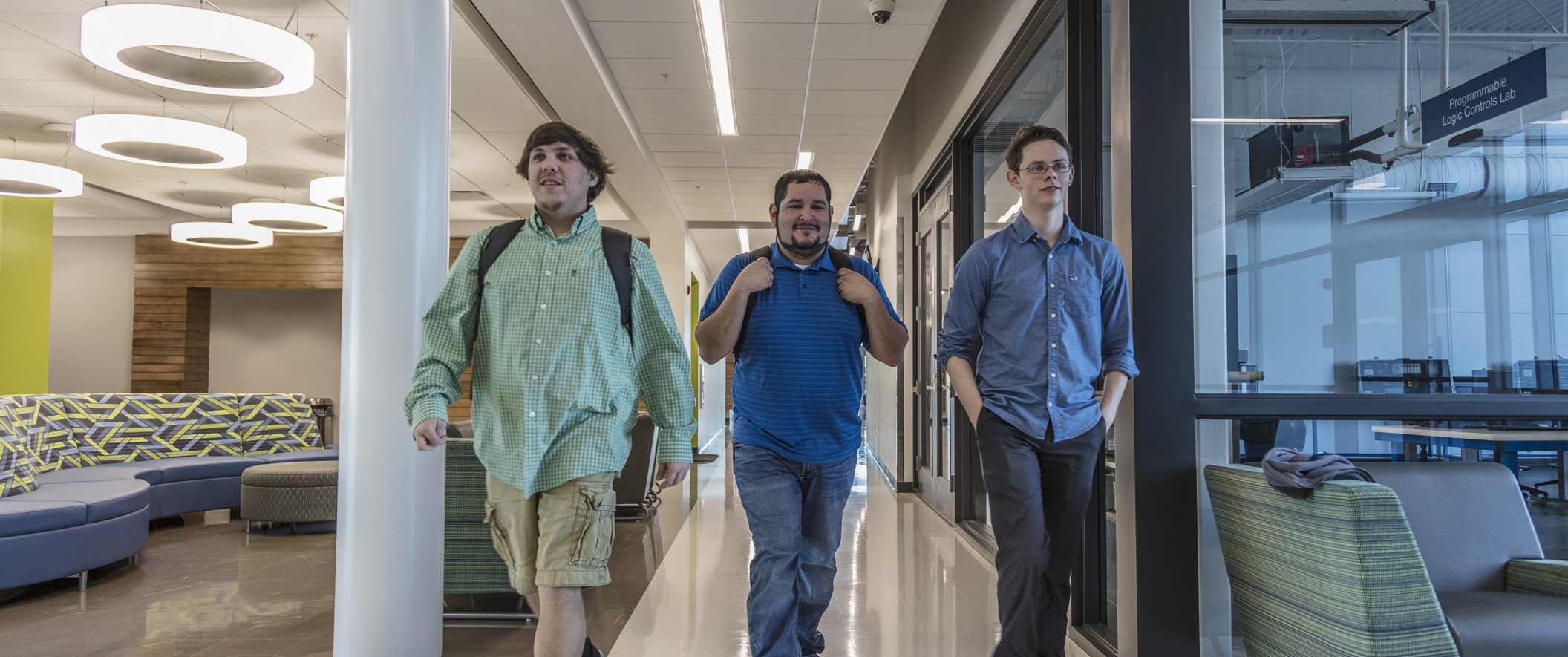 three male students walking down a hallway